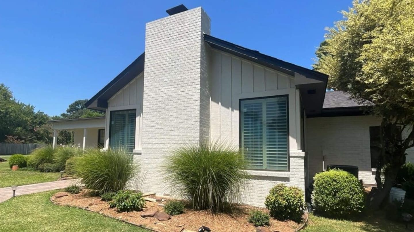 Exterior brick painting project by Derheim Painting in Ardmore OK — white painted brick with black trim