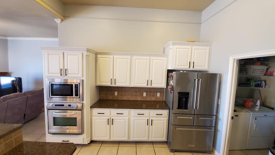 A successful kitchen cabinet painting project has transformed these cabinets with a clean, white finish.
