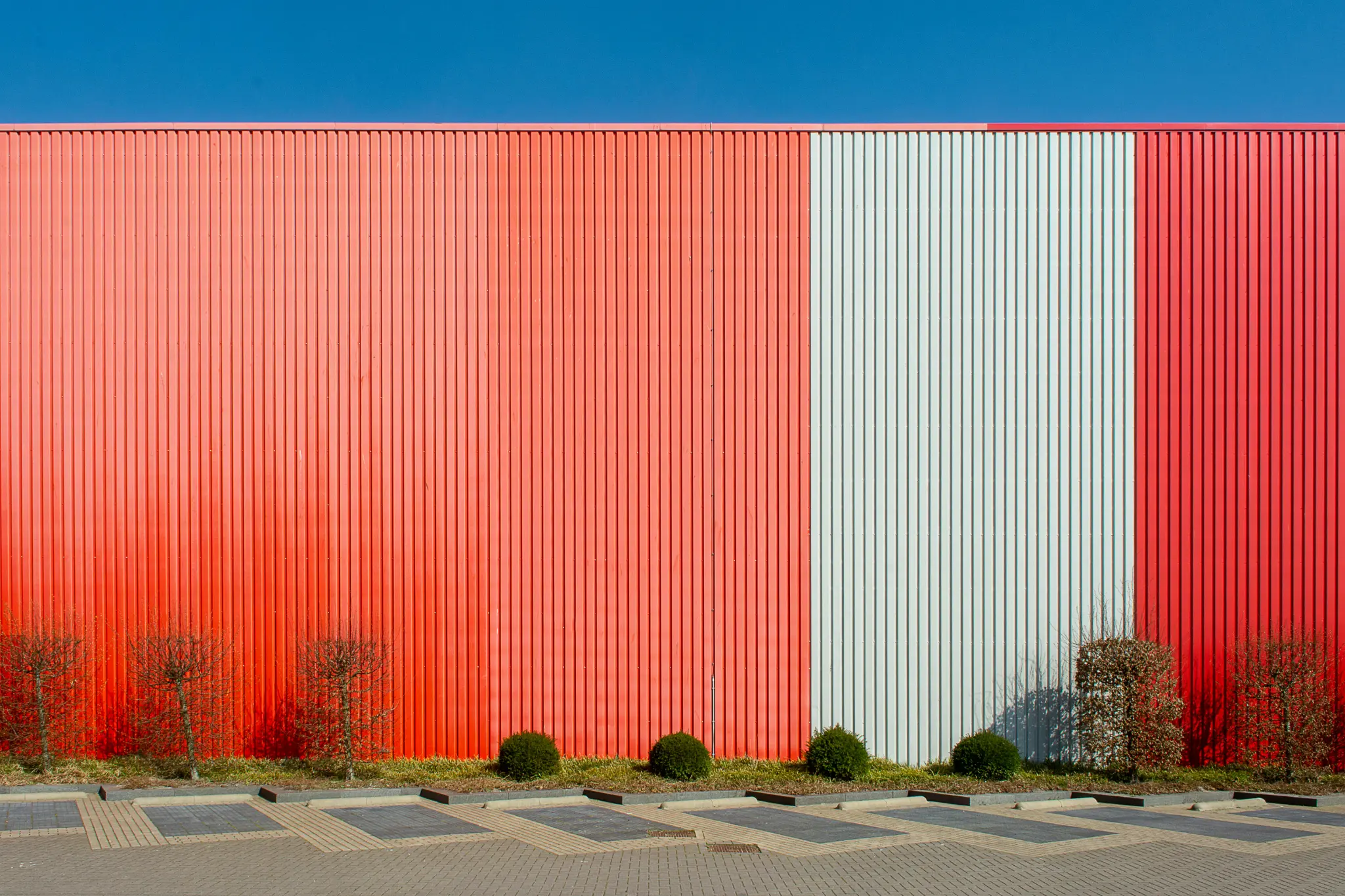 The commercial exterior painting cost for a large warehouse with corrugated metal siding like this is influenced by the surface area and the number of colors used
