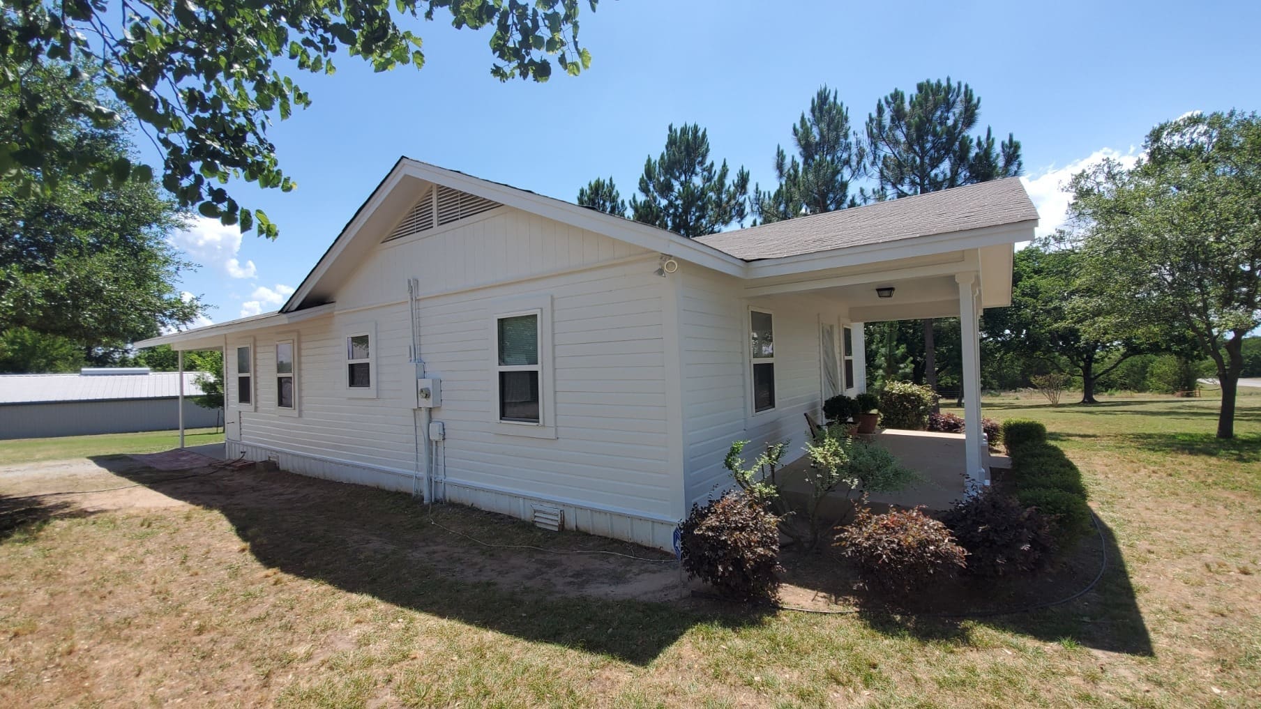 Derheim Painting white lap siding exterior painting on a rural Oklahoma home