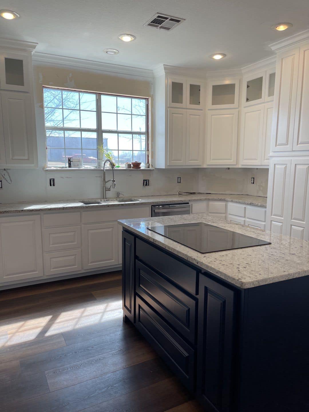 Derheim Painting contrasting white upper and dark island cabinet painting in Ardmore, OK