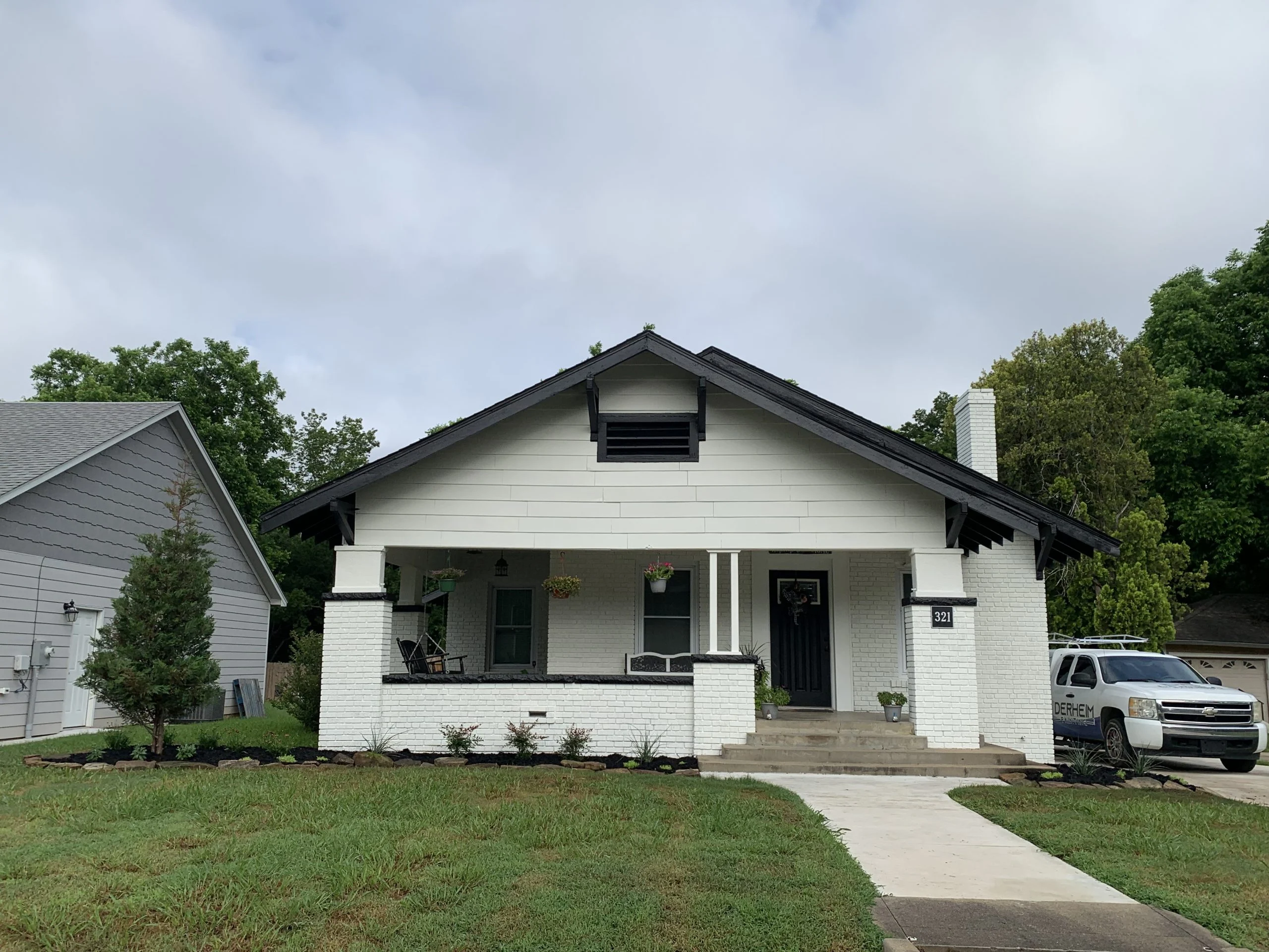 Derheim Painting truck parked at completed exterior home painting project in Kingston, OK